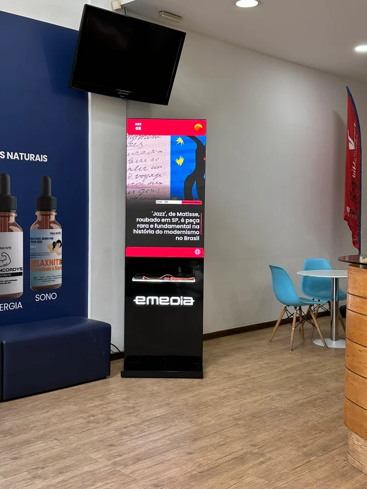 Totem Emedia com conteúdo informativo em área de atendimento